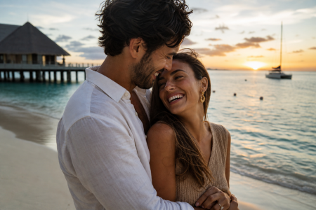 Pareja celebrando su viaje de novios original en una playa exótica al atardecer con ViajesDQ