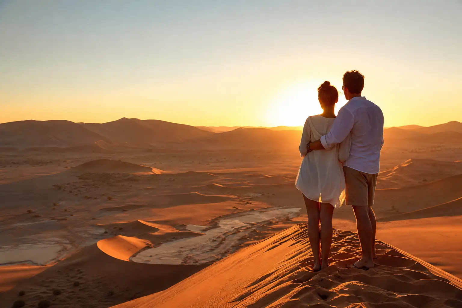 Pareja en viaje a medida a Namibia contemplando las dunas de Sossusvlei al amanecer